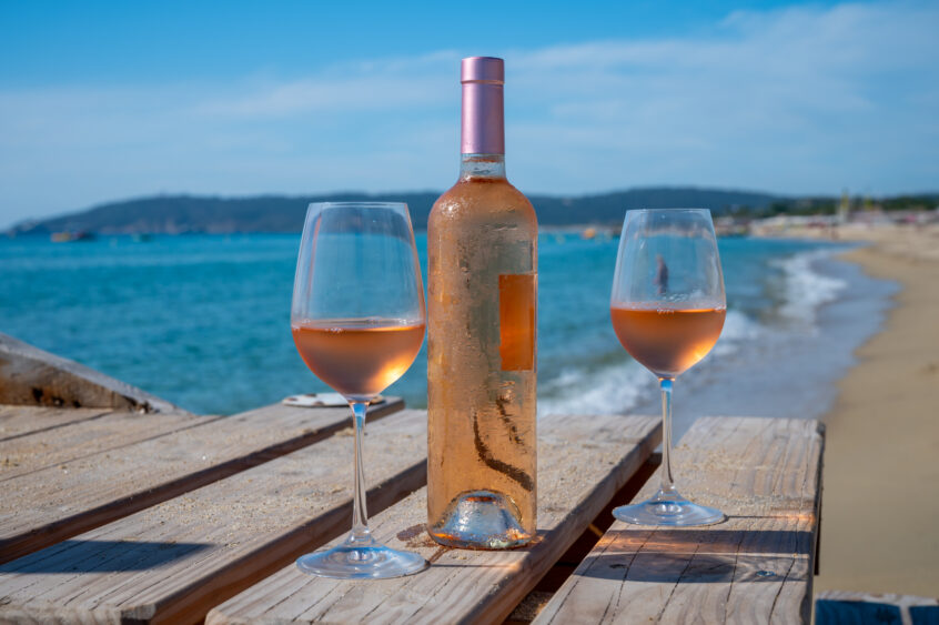 Rosé wine glasses and bottle on a deck